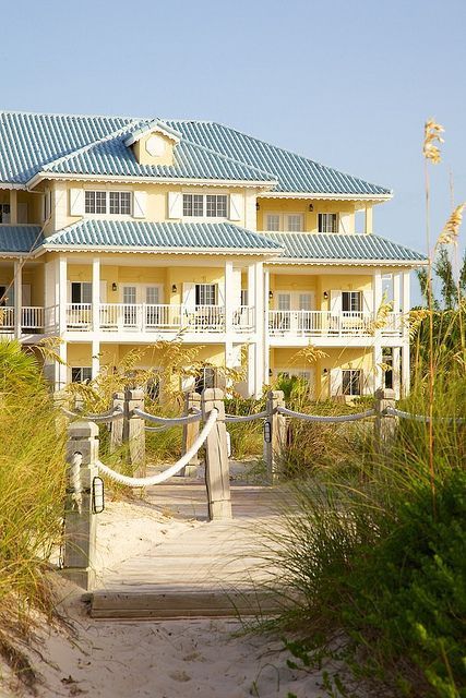 Coastal home with a fun yellow exterior Yellow Beach House, Sunset Cocktail, Beautiful Property, Blue Roof, Coastal House, Romantic Ideas, Dream Beach Houses, Haus Am See, Turks Caicos