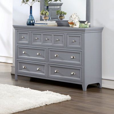 A soft gray painted finish brings an updated ambiance to this transitional seven-drawer dresser. Drawer fronts feature crown molding trim details that create wonderful texture and dimension within your stylish bedroom. They're dotted with a mix of metallic, cupped drawer pulls and round knobs for a shiny accent that allows for easy access to contents within each of the seven spacious storage drawers. | Wade Logan® Bruun 7 Drawer 56" W Dresser Wood in Brown / Gray | 36 H x 56 W x 18 D in | Wayfai Gray Dresser, Transitional Dresser, Cup Drawer Pulls, Traditional Dressers, Dresser Wood, Grey Dresser, 7 Drawer Dresser, Dressers For Sale, Dresser Sets