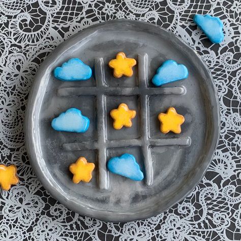 Elevate your game nights to a whole new level with our Handmade Full Moon and Stars Tic-Tac-Toe Board. This exceptional creation is more than just a game; it's a piece of art that beautifully combines celestial inspiration with craftsmanship. With its hand-painted full moon, starry X's, cloudy O's, and a glossy resin finish, this one-of-a-kind board is sure to capture hearts and create lasting memories. Board Features: 🌕 Full Moon Design: The game board takes the form of a radiant full moon, in Air Dry Tik Tak Toe, Air Dry Clay Board Game, Air Dry Clay Ideas Tic Tac Toe, Tiktaktoe Board Clay, Cute Tic Tac Toe Board, Air Dry Clay Checkers Board, Air Dry Clay Fortune Cookie, Pizza Tic Tac Toe Clay, Clay Crafts Tic Tac Toe