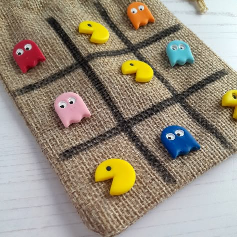 New for Christmas 2022!  A fabulously retro version of my popular Tic Tac Toe games, this one features cute little Pacman and five different coloured ghosts!  Made of polymer clay, into flat back pieces, to use for the classic game of Tic Tac Toe, or Noughts and Crosses!  The kit includes 5 pieces of each style/colour, so 10 pieces in total to play a game, along with a hessian drawstring bag with the grid hand drawn on it to play! Keep all of your pieces safe inside too! It's also great for trav Clay Tick Tack Toe Board, Tik Tac Toe Clay Board, Clay Tic Tac Toe Board Ideas, New For Christmas 2022, Clay Tic Tac Toe Board, Clay Games, Tic Tac Toe Diy, Pottery Games, Noughts And Crosses