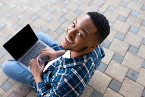 Above view of black man using personal computer sitting on the stairs in city, looking at camera, mock up Sitting Above View Reference, Person Looking Up At Camera, Person Sitting On Stairs, Person Looking Up Reference From Above, Person Looking At Camera, Sitting Pose Reference, Indonesian Art, Sitting Poses, Man Sitting