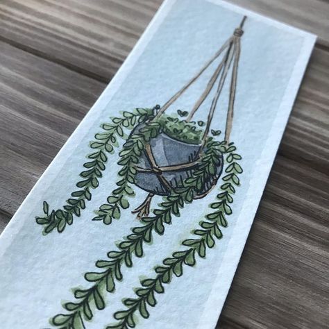 Grace Thornock on Instagram: “Painted a hanging house plant bookmarked this my @artisticisle.watercolor palette! I am also testing out a varnish I bought to protect it.…” Witchy Drawings, Cottagecore Illustration, Plant Bookmark, Plant Watercolor, Hanging House, Dorm Art, Watercolor Journal, Watercolor Bookmarks, Art & Craft Paint