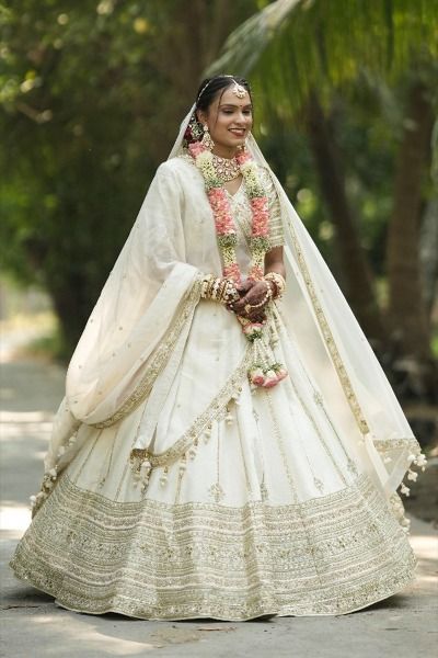 '24 | Bride from Vapi, India in TASTA-designed ivory silk lehenga choli adorned with tissue dupatta. The lehenga bottom has horizontal hand embroidery highlighting whole look and composed with vertical strips, above hortizontal patch, upto the top of lehenga. Groom Fashion, Embroidery Border, Women Bride, Chaniya Choli, Gowns Of Elegance, Ivory White, Bride Groom, Timeless Beauty, Indian Fashion