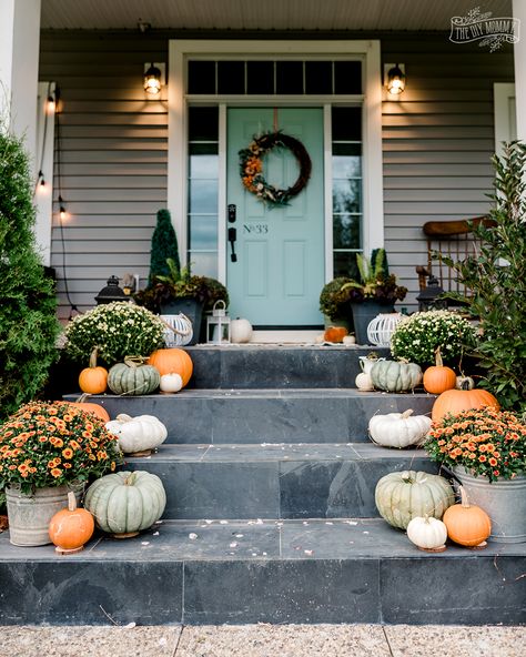 Beautiful Fall porch with pumpkins, mums, soft orange and aqua blue green. Plastic Pumpkin Flower Pot, Green Fall Decor, Pumpkins Porch, Breakfast Nook Decor, Pumpkin Porch, October Decor, Fall Porches, Mums In Pumpkins, Fall Patio