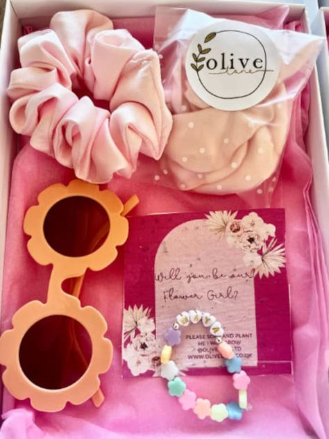 Personalised Flower Girl Proposal box Bracelet, Flower Sunglasses, Satin Petals and Hair Scrunchie all in a gift box lined with white tissue paper and frayed chiffon ribbon. - Beaded Flower bracelet with your flower girl's name which is attached to some seed paper with 'Will You Be Our Flower Girl?' on it. - Blue Flower Sunglasses - Handmade silk hair scrunchie - Light blue satin reusable flower girl petals - White Gift Box lined with tissue paper and tied with ribbon. Perfect proposal gift box Flower Girl Proposal Ideas, Asking Flower Girl, Flower Girl Petals, Hen Party Bags, Flower Girl Proposal, Flower Sunglasses, Handmade Sunglasses, Flower Girl Bracelets, Girl Bracelet