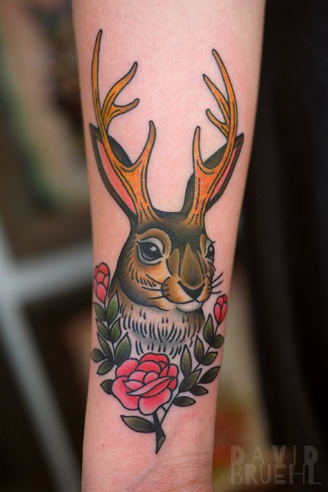 Traditional Jackalope Rabbit Tattoo with roses on a forearm. by David Bruehl at RedLetter1 in Tampa, Florida Jack Rabbit Tattoo Traditional, American Traditional Jackalope Tattoo, Jackalope Skull Tattoo, Rabbit Tattoo Neotraditional, Animals In Clothes Tattoo, Jack Rabbit Tattoo, American Traditional Rabbit, Jackrabbit Tattoo, Traditional Bunny Tattoo