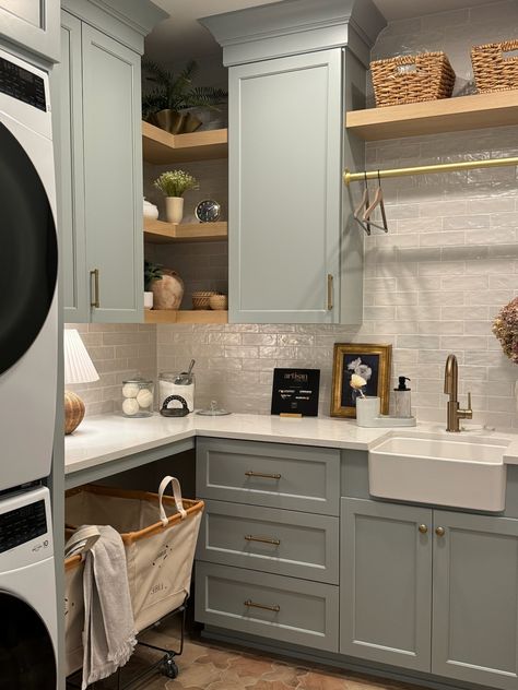 Completely swooning over this perfect laundry room featuring these pale blue cabinets and sparkling white backsplash! The open oak shelving provides additional storage while also providing some warmth to the space!    New Construction | Home Trends 2024 | Home Design | Minnesota Home Trends Oak Laundry Room, Blue Cabinets In Laundry Room, Dark Blue Laundry Room Cabinets, Blue Cabinet Laundry Room, Blue Laundry Room, Laundry Room Color Ideas, Perfect Laundry Room, Laundry Room Colors, Blue Laundry Rooms