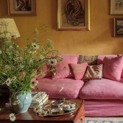 Clever with colour: Tis the season for comfy sofas, and look at this peach! This room is the perfect colour clash, and a reminder that bright can also mean harmonious. And its offset by a symphony of textures, from the wonky cottage walls to the loose linen sofa cover, the wool rug and the shiny gold frames. Perhaps unsurprisingly, the cottage belongs to an artist @occymackenzie who painted the whole house herself. Photo by @davewattsphotography #CleverWithColour #lateafternoonlife #int... Santa Fe Living Room, Cottage Walls, Peach Living Rooms, Linen Sofa Cover, Living In London, Cosy Room, Pink Sofa, Yellow Home Decor, Cosy Living Room