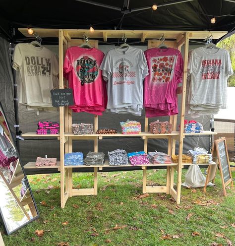 Clothing Trade Show Booth Ideas, Diy Shirt Display Rack, Market Booth Display Tshirts, Festival Boutique Booth, Craft Fair T Shirt Display, How To Display Shirts For Sale Craft Fairs, Craft Show Tent Ideas, Portable Clothing Display, Diy Craft Booth Backdrop