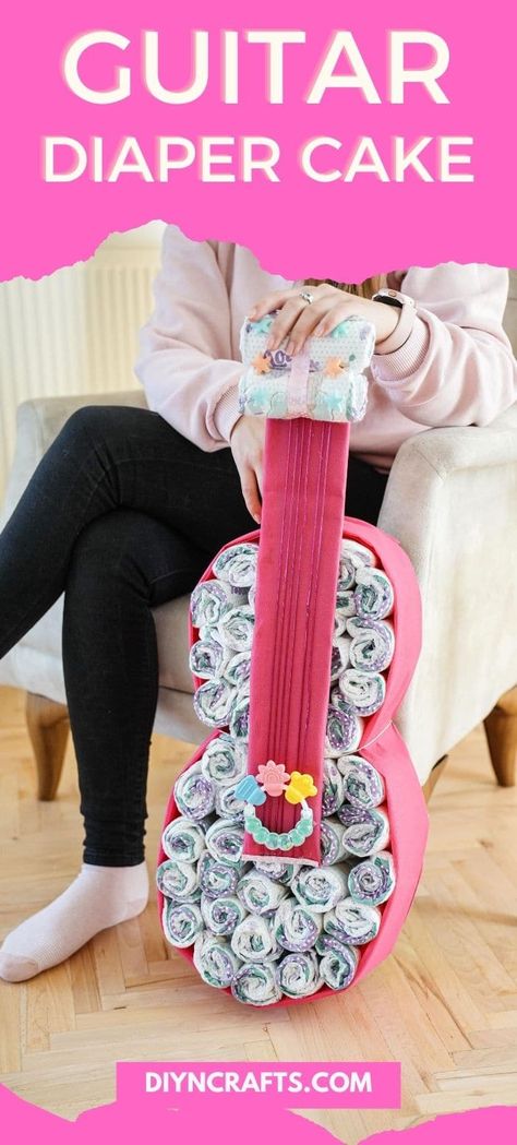 Follow this easy tutorial to create a guitar diaper cake baby gift that is sure to wow everyone at your next baby shower event! This baby shower gift also doubles as an amazing baby shower decoration that is cute and fun! #BabyShowerGift #DiaperCake #Guitar #BabyShowerDecorations Music Themed Baby Shower Ideas, Rock Baby Showers, Diaper Cakes Tutorial, Diy Diaper Cake, Airplane Baby Shower, Baby Diaper Cake, Baby Shower Decoration, Toilet Paper Roll Crafts, Boy Stuff