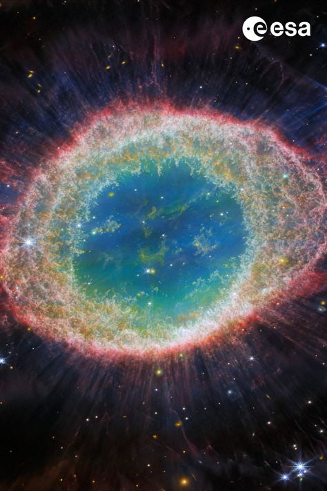 This image of the Ring Nebula appears as a distorted doughnut. The nebula’s inner cavity hosts shades of blue and green, while the detailed ring transitions through shades of orange in the inner regions and pink in the outer region. The ring’s inner region has distinct filament elements Ring Nebula, Hubble Space Telescope Images, Planetary Nebula, Helix Nebula, Astronomy Lover, Hubble Telescope, James Webb, James Webb Space Telescope, Hubble Space