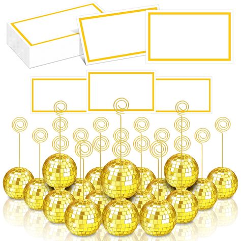 PRICES MAY VARY. Complete Set to Display Cards: you will get 20 pieces of gold disco ball card holders, 20 pieces of gold metal wire clips, and 20 pieces of table number cards with gold foil frame, enough and nice combination to meet your table using needs, bring your table settings a kind of charming disco visual feeling Proper Size: the disco ball table card holder stand is about 2 inches/ 5 cm, the wire clip is about 4.7 inches/ 12 cm long, suitable for you to install and see them; The card i Disco Ball Table, Table Number Stand, Cheer Banquet, Table Number Stands, Gold Centerpieces, Table Name Cards, Table Card Holder, 70s Party, Name Card Holder