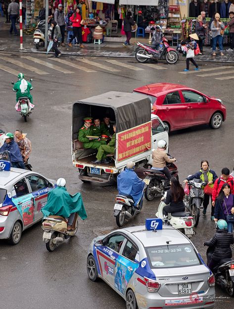 In Hanoi, Vietnam, the primary mode of transportation is the bicycle, either motorized or not.  Traffic moves in a controlled chaos with anticipation skills at a premium!  Once you add a car or truck, it all seems to clog up. This is the full view of the traffic below where I captured the vignettes.    #traffic circle, #rainy day, #uniforms, #travel portrait, #street photography, #street photography worldwide, #chaos, #asian, #city, #traffic, #intersection, #vietnam, #bikes, #motorcycles Portrait Street Photography, Vietnam Motorcycle, Asian City, Medium Format Photography, Controlled Chaos, City Traffic, Photography Shop, Photographers Gallery, Photography Street