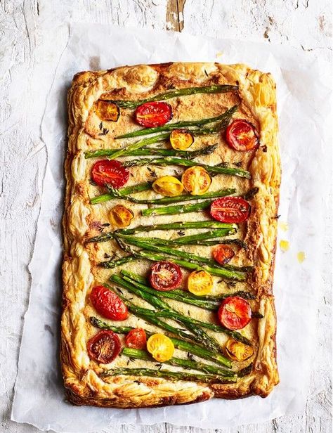 Asparagus Frangipane Tart Recipe with Cherry Tomatoes Try our vegetarian tart recipe, topped with vibrant tomatoes and asparagus, for an easy vegetarian entertaining idea Veggie Tart Puff Pastries, Heirloom Tomato Tart Puff Pastry, Tomato Tart Puff Pastry Pesto, Cherry Tomato Puff Pastry, Summer Luncheon Menu Ideas, Puff Pastry Tart Savory, Veggie Tart Recipes, Asparagus Pie, Spring Tart