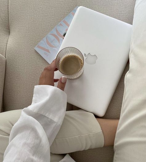 A girl sitting on a couch holding a cup of iced coffee with a laptop and magazine. Laptop Lifestyle Aesthetic, White Wellness Aesthetic, White Lifestyle Aesthetic, White Business Aesthetic, White Laptop Aesthetic, Magazine Work Aesthetic, Coffee Laptop Aesthetic, Girl With Coffee Aesthetic, Coffee And Laptop Aesthetic