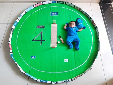 Baby photoshoot idea for monthly birthday celebration at home. My IPL#Cricket theme baby photoshoot idea is for my baby girl Shriya. She completed 4months during IPL, so it was a good idea with 4 Runs in a cricket match. 
I made the pitch from cardboards and green and brown cardpaper. The boundary with black cardpaper and as we see the ongoing advertisements at stadium I took the printouts of all baby products for the add. And the bat ball were made out of thermocol to meet the size of my baby. Ipl Theme Photoshoot, Cricket Theme Photoshoot, Cricket Theme Baby Photoshoot, Monthly Birthday Photoshoot Ideas, Sankranthi Theme Baby Photoshoot, 1 Month Photoshoot Ideas, Baby Theme Photoshoot, 4month Baby Photoshoot, 4 Months Baby Photoshoot Ideas