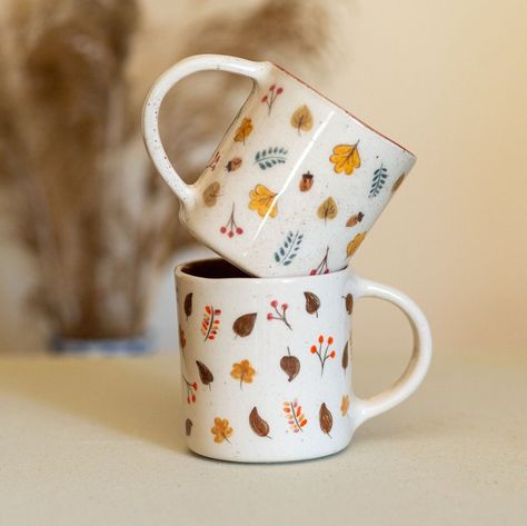 🍂 Fall Mug Set, Pumpkin Spice Mug, Handmade Ceramic Mug Set | Set of 2 🍂 Target Audience: For those seeking artisanal coffee cups, ceramic coffee cup enthusiasts, autumn-themed coffee cup seekers, those in search of a coffee cup set, individuals looking for home gifts, autumn-themed gift seekers, tea cup enthusiasts, connoisseurs of handmade gifts, those seeking new job gifts, those in need of new home gifts, and admirers of autumn-themed kitchen decor. Product Features: This artisan-crafted masterpiece is a set of two intricately shaped and hand-painted mugs. Adorned with exquisite autumn leaves in rich, warm shades, it's a stunning addition to your décor. Product Benefits: 😍 Aesthetic Excellence: Elevate your coffee time with these mugs that are not just functional but also a piece of Autumn Coffee Mugs, Ceramic Painting Fall Ideas, Pumpkin Ceramic Mug, Autumn Mug Painting Ideas, Pottery Painting Autumn, Fall Mug Painting Ideas, Autumn Pottery Painting, Hand Painted Pottery Mugs, Coffee Mug Painting Ideas