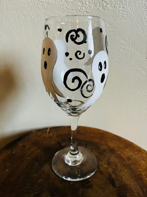 This is a painted Ghostly Halloween wine glass. I used acrylic painted and baked them so that the paint is set so they can be put in the washer but I would always recommend hand washing wine glasses whether painted or not. I love Halloween and I just thought that these would be a cute way to celebrate the holiday. Spooky Wine Glass Painting, Halloween Painted Wine Glasses, Halloween Wine Glass Painting, Fall Painted Wine Glasses, How To Paint Wine Glasses, Halloween Wine Glasses Diy, Halloween Wine Glasses, Bottle Art Projects, Horror Crafts