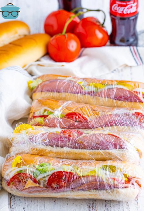 A few Kmart Subs wrapped in plastic laying in a line. Kmart Subs, Party Appetizer Dips, Muffaletta Sandwich, Sub Rolls, Dill Pickle Chips, Best Banana Pudding, Deli Sandwiches, Sub Sandwiches, Country Cook