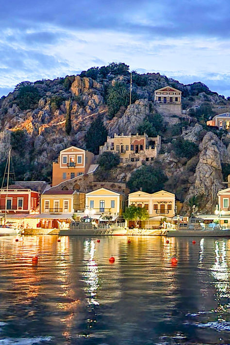 Colorful buildings along the harbor in Symi at night. Best Islands In Greece, Symi Island Greece, Greek Islands Aesthetic, Pastel Architecture, Ikaria Greece, Greece Aesthetics, Symi Greece, Aesthetic Greek, Greek Aesthetic