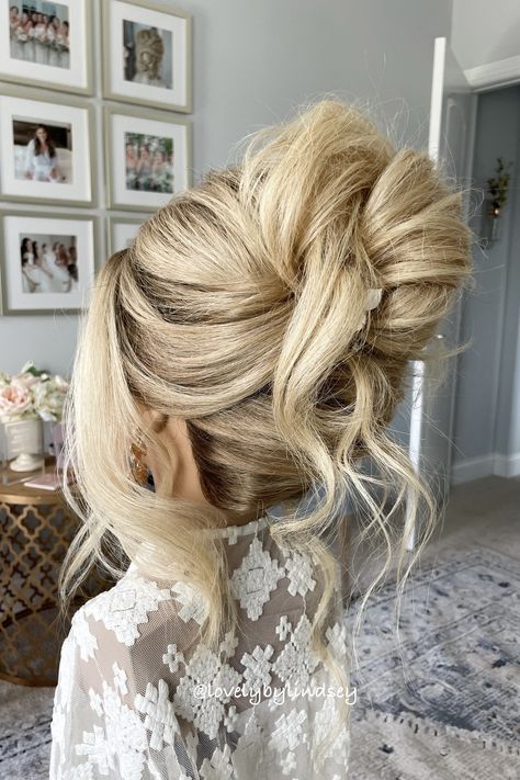 High tousled updo on blonde hair for weddings. Hair High Updos, Piled High Updo, Bridal Volume Updo, 2025 Bridal Hair Trends, Messy French Twist Updo, Bridal Hair Updo Blonde Classy, High Bridal Updo, Bridal High Updo, Low Messy Bun Wedding Hair