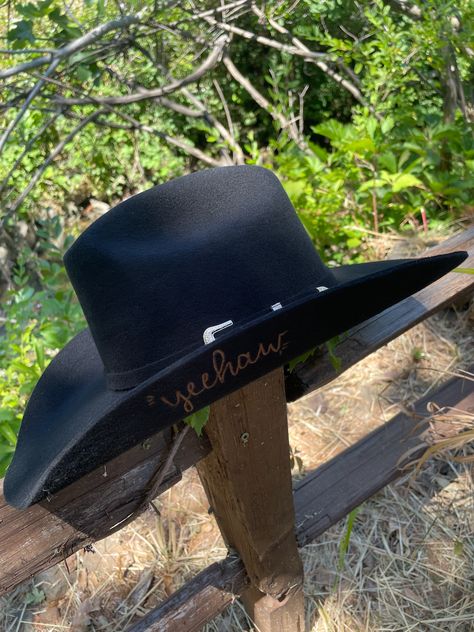 Black wool cowboy or cowgirl hat with the word "yeehaw" burned into the brim on the underside in cursive Black Cowgirl Hat Aesthetic, Western Black Hat With Feathers, Cowgirl Hat Black, Black Cowgirl Hat, Black Brimmed Western Felt Hat, Black Brimmed Western Hats, Daisy Hat, Burned Hats, Black Cowgirl