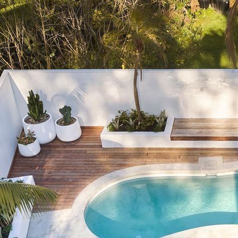 Pool Area Renovation, Modern Coastal Pool Area, Curved Pool Landscaping, Update Pool Area, White Pool Decking, Backyard Inspo With Pool, Oval Pool Landscaping, Modern Kidney Shaped Pool, Coastal Pool Landscaping