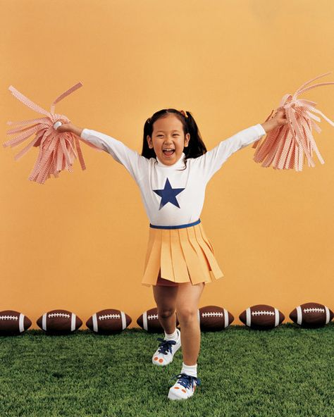 Hip, hip, hooray! The crowd will go wild for this cheerleader and her very cheer-full ensemble. The pleated skirt is made from strips of yellow sponge cloths and blue tape, and the pom-poms are made from checkered mop heads. Bright shoelaces, dot stickers, and a paper-star cutout deserve extra applause. Diy Cheerleader Costume, Cheerleader Costume Kids, Easy Homemade Costumes, Cheerleader Poses, Halloween Costumes Kids Homemade, Cheerleader Halloween, Diy Fantasia, Cheerleader Halloween Costume, Homemade Costume