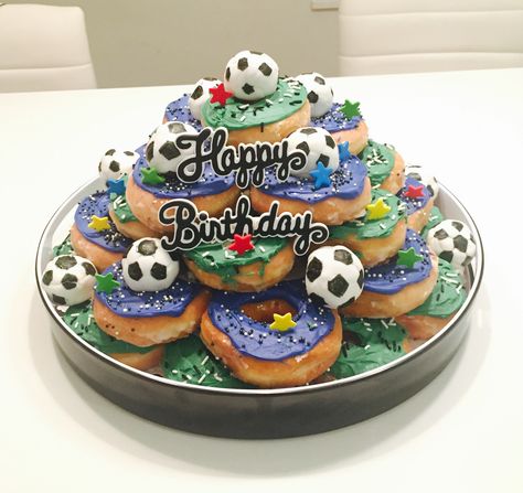 Soccer donut birthday cake⚽️!! Very simple and fun to make. Just spread icing over some plain donuts and add sprinkles To make the mini soccer balls, wrap white fondant around donut balls, and draw the black pentagons with an edible marker. Soccer Donut Cake, Soccer Donuts Ideas, Birthday Donuts Ideas Boy, Plain Donuts, Birthday Cake Fruit, Donut Balls, Birthday Cake Simple, Donut Cakes, Mini Pastelitos