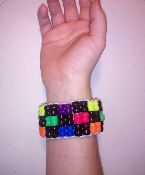 This super cute neon rainbow and black checkered bracelet is the perfect way to brighten up your day! Stretchy and durable, select your size for the best fit! Scene Kid Bracelets, Clowncore Kandi Bracelets, Lgbtq Kandi Bracelets, Domo Kandi Cuff, Rainbow Road Kandi Cuff, Scene Kandi Cuff, Bracelets Kandi, Scene Accessories, Candy Bracelet