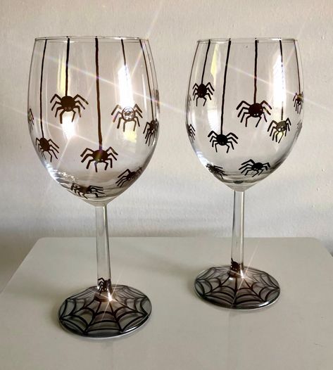 Happy Spooky Season!! This creepy crawly wine glass includes Hand Painted spiders! There are 8 spiders on webs and a few more below them on these MADE TO ORDER glasses. The spiders cover one half of the glass. Each spider has been detailed with 8 little legs and a set of two eyes (there should be 6.. but that's okay!). These spiders are descending from the top of the glass and on their way back to their spiderweb below! Depending on which glass style you choose, you will see a spiderweb on the bottom of your glass. These glasses are the perfect gift for any lover of spooky things, spiders, or Halloween fun!  I also offer several other Fall/Halloween designs. Please contact me if you would like to mix and match a SET of Glasses with others in my shop. I would be happy to create a "private l Halloween Diy Wine Glasses, Halloween Cup Painting Ideas, Glass Halloween Decor, Halloween Glass Painting Ideas, Halloween Shot Glasses Diy, Spooky Wine Glasses, Halloween Wine Glasses Diy Painted, Paint Your Own Wine Glass Diy, Halloween Painted Glasses