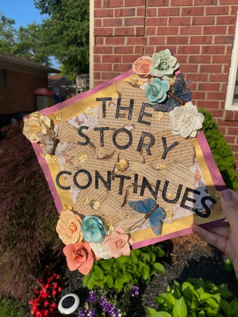 A grad cap with a detailed background with pages from books scattered across. It is covered with gold flakes, butterflies, and flowers. It reads “the story continues”. And My Story Continues Graduation Cap, Graduation Things, Senior Things, Grad Cap Designs, Cap Decoration, Grad Caps, Cap Ideas, Graduation Quotes, Graduation Caps