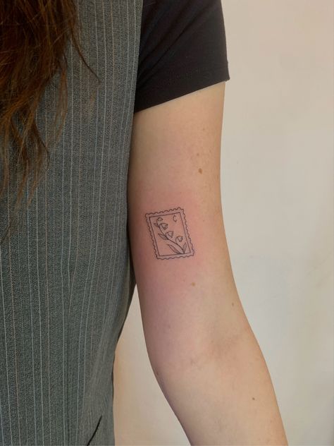 Minimal Thistle Tattoo, Aster Stamp Tattoo, Flower Tattoo Symbolism, Post Stamp Tattoo Small, Post Stamp Tattoo Aesthetic, Cowboy Stamp Tattoo, Lily Stamp Tattoo, Postage Stamp Tattoo Placement, Floral Stamp Tattoo