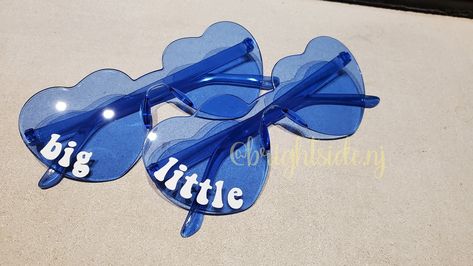 "This listing is for 3 pairs of heart shaped glasses!  This is a set of 3! One says big one says little and one says middle!  These are perfect for sorority, cheer or dance big little reveals! Text is in white and will go on the right \"eye\" Personalization is done is premium vinyl. Message me for more color options." Big Little Hint Ideas, Big Sis Lil Sis Gifts, Cheer Team Gift, Big Lil Gifts, Big/little Baskets, Little Gifts Sorority, Big Little Canvas, Cheer Team Gifts, Big Little Basket