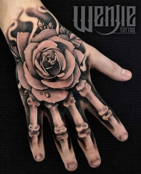 Rose skeleton hand tattoo with water drop on petal Skeleton Hand Tattoos With Rose, Rose Hand Tattoo With Skeleton Fingers, Skellington Hand Tattoo, Mens Skeleton Hand Tattoo, Tattoo Ideas For Hands Men, Arm To Hand Tattoo Men, Skull Finger Tattoo For Women, Hand Tattoos For Guys Stencils, Hand Tattoos Men Ideas