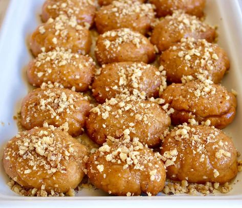 Melomakarona, the most popular Greek Christmas Cookie! Juicy aromatic cookies with a hint of cinnamon and orange drenched in a honey syrup and topped crushed walnuts. Get the authentic step by step recipe for this juicy, decadent and delicious Greek Christmas honey cookie. Melomakarona are by far the most popular holiday cookie in Greece. And... Greek Cookies Melomakarona, Greek Shortbread Cookies, Greek Christmas Cookies Recipes, Koulourakia Recipe Greek Cookies, Greek Honey Cookies, Greek Cookies Koulourakia, Greek Christmas Food, Greek Cookies Recipes, Kaymak Recipe