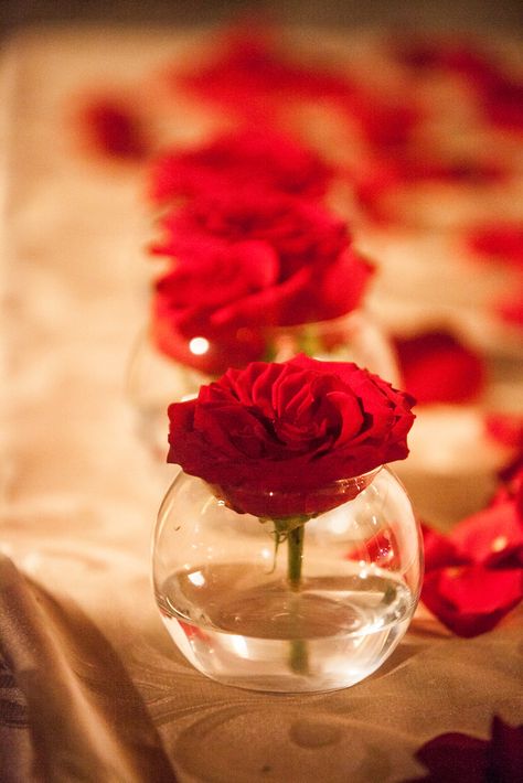 Gift table decoration, red roses in vase with rose petals Red Centerpieces Diy, Rose Petal Decor, Rose Table Decorations, Red And White Table Decor, Rose Petals On Table, Red Rose Table Decor, Red Rose Table Centerpiece, Red Rose Decorations, Red Roses Table Decor