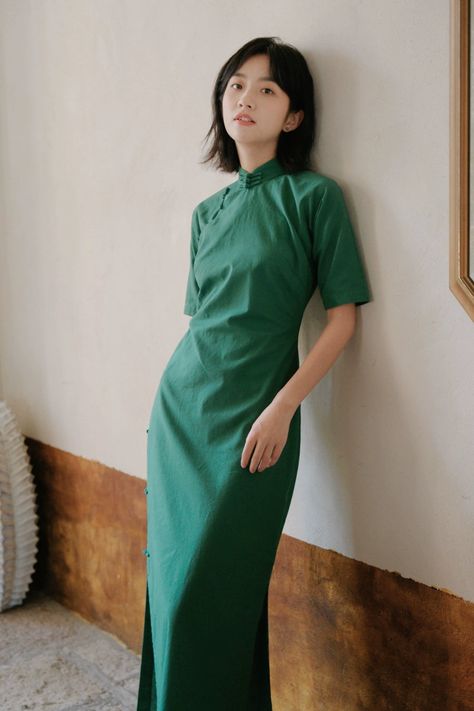 1930s style qipao 旗袍 made of natural cotton and ramie plant fibers create the perfect every dress! In a gorgeous forest green shade, this 30s qipao features vintage half sleeves that create a flattering silhouette, traditional Chinese knot buttons, and lower side slits. Created to be loose around the waist, vintage cheongsams are not as constricting as modern cheongsams making them extremely comfortable for daily wear. The Xiao Senlin 小森林 Little Forest Qipao is versatile piece for layering or to Vietnamese Street Style, Cheongsam Inspired Dress, Chinese Qipao Traditional, Chinese Modern Fashion, Chinese Summer Outfits, Dress China Style, China Outfits Style, Modern Traditional Dresses, Winter Qipao