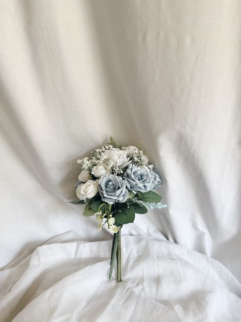 This beautiful bunch of faux flowers consists of roses and buds of white and dusty blue colors accompanied with faux fillers. It will be a perfect touch to any table.  Arrangement measures: W - 6" , H - 11 "approx. Matching bridal and bridesmaids bouquets, toss bouquet, corsages and boutonnières and other accessories are available. Blue Flowers Centerpiece, Blue And White Boutonniere, Simple Wedding Table Centerpieces, Blue Flower Centerpieces, Centerpieces Blue, Small Bridesmaid Bouquets, Kou Diabolik Lovers, Brides Flowers Bouquet, Toss Bouquet