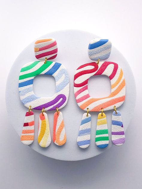 These bright rainbow swirl dangle earrings evoke the look of a painter's brushstroke. They are such a fun and bright statement earring for any look.  They measure 3.25 inches in length and 1.5 inches in width.  Polymer clay is extremely lightweight, making them very comfortable to wear. I have had several customers say that they forget they are wearing them because they are so comfortable.  In addition, the posts are titanium so even those with very sensitive ears can wear them without any issue Colourful Polymer Clay Earrings, How To Make Earrings With Clay, Funky Clay Earrings, Diy Earrings Polymer Clay, Polymer Clay Jewelry Tutorials, Polymer Earrings, Funky Earrings, Polymer Crafts, Handcrafted Accessories