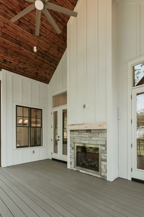 Featuring white board and batten siding in Sherwin Williams Aesthetic White and a double-sided fireplace, this screened porch is perfect for relaxing or entertaining Ceiling Pine Beadboard Beaded side down Color Minwax Honey Fireplace Stone Coronado Old World Ledge in Cape Cod Gray #boardandbatten #siding #screenedporch #fireplace White Board And Batten Siding, White Board And Batten, Board And Batten Exterior, Porch Fireplace, Vertical Siding, Double Sided Fireplace, Beadboard Ceiling, Board And Batten Siding, Construction Home