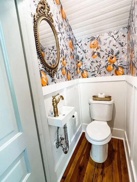 a chic and tiny under the stairs powder room with bold wallpaper and paneling, a wall mounted sink and a mirror in a vintage frame Stairs Powder Room, Understairs Toilet, Tiny Half Bath, Tiny Powder Rooms, Room Under Stairs, Small Half Bath, Tiny Powder Room, Small Downstairs Toilet, Small Powder Room