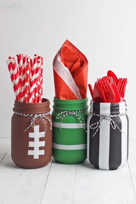 Hosting a Super Bowl party? Wow your guests with a bunch of football mason jars! These cute football themed party ideas are great to use as utensil holders or centerpieces! Football Mason Jars, Fairy Party Crafts, Diy Football Party, Football Centerpieces, Money Party, Superbowl Party Decorations, Mason Jar Party, Super Bowl Decorations, Jello Cups