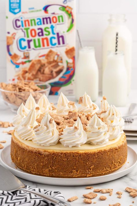 Cinnamon Toast Crunch Cheesecake on a white plate with a box of cinnamon toast crunch on the background. Cinnamon Toast Cheesecake, Cinnamon Toast Crunch Cheesecake Recipe, Cinnamon Toast Crunch Cheesecake, Peanut Butter Cheesecake Recipes, Apple Crisp Cheesecake, Cheesecake Factory Recipes, Protein Cheesecake, Crunch Cake, Cinnamon Toast Crunch