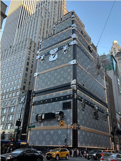 An amazing sight in New York City's midtown! Such an imaginative, whimsical way to deal with an ordinary business headache. To cover up construction on its flagship store, Louis Vuitton designed its scaffolding--usually an eyesore—into a tourist attraction. The 15-story building looks like a stack of its famous steamer trunks.  Via Gretchen Rubin Louis Vuitton Building Nyc, Louis Vuitton New York Building, New York Louis Vuitton Store, Store Louis Vuitton, Louis Vuitton Suitcase, Nyc Places, Gretchen Rubin, New York Buildings, Hamptons Summer