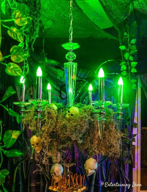 Green light bulbs in the chandelier give a spooky indoor Halloween lighting effect Halloween Chandelier, Halloween Lighting, Halloween Entertaining, Haunted House Decorations, Halloween Graveyard, Halloween Tutorial, Diy Halloween Decor, Halloween Scene, Halloween Displays