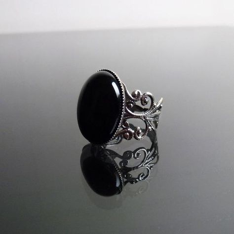 This ornate ring features a natural gemstone Black Onyx cabochon (18 x 13 mm) on a stunning filigree band. The Sterling silver plated filigree ring is adjustable so one size fits all. The Black Onyx gemstone cabochon is a deep, glossy black and catches the light beautifully. Nickel and lead free. The Bella ring is available in Black Onyx, Ruby red and Sapphire blue. This Bella Black Onyx filigree ring perfectly complements many of our chokers. **************************************************** Steampunk Rings, Ornate Ring, Gothic Ring, Victorian Steampunk, Gothic Rings, Steampunk Jewelry, Onyx Gemstone, Victorian Gothic, Filigree Ring