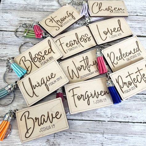 Show your faith in style with our scripture word keychain. Crafted with 1/8 inch thick maple wood and laser cut, this stylish keychain features the word Redeemed engraved for a special touch. A meaningful addition to your daily life or inspirational gift for someone. Keychain measures 2.5 in wide x 2 in high *Tassel colors are chosen at random. We cannot guarantee specific colors Scripture Crafts For Women, Laser Engraved Keychain Ideas, Christian Crafts To Sell, Keychain Design Ideas, Word Keychain, Laser Keychain, Rosary Keychain, Scripture Crafts, Xtool Projects