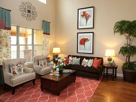 A coral-colored rug pulls together the design in this living room, uniting the pops of color found in the curtains, artwork and pillows. The neutral chairs and sofa blend into the background and let the coral and turquoise elements shine. Turquoise Bedroom Walls, Coral Living Room, Coral Living Rooms, Coral Curtains, Turquoise Living Room Decor, Turquoise Room, Living Room Turquoise, Brown Living Room Decor, Teal Living Rooms