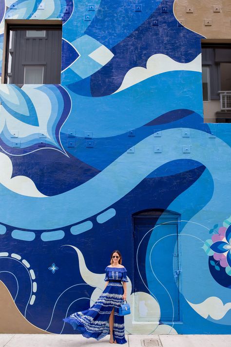 Jennifer Lake Style Charade wearing a blue pleated Self Portrait maxi dress, and blue Henri Bendel bag at a blue swirl mural wall Abstract Ocean Wall Mural, Water Wall Mural, Sea Mural Painting, Blue Mural Wall, Swirl Mural, Grafitti Murals, Ocean Murals, River Mural, Water Mural